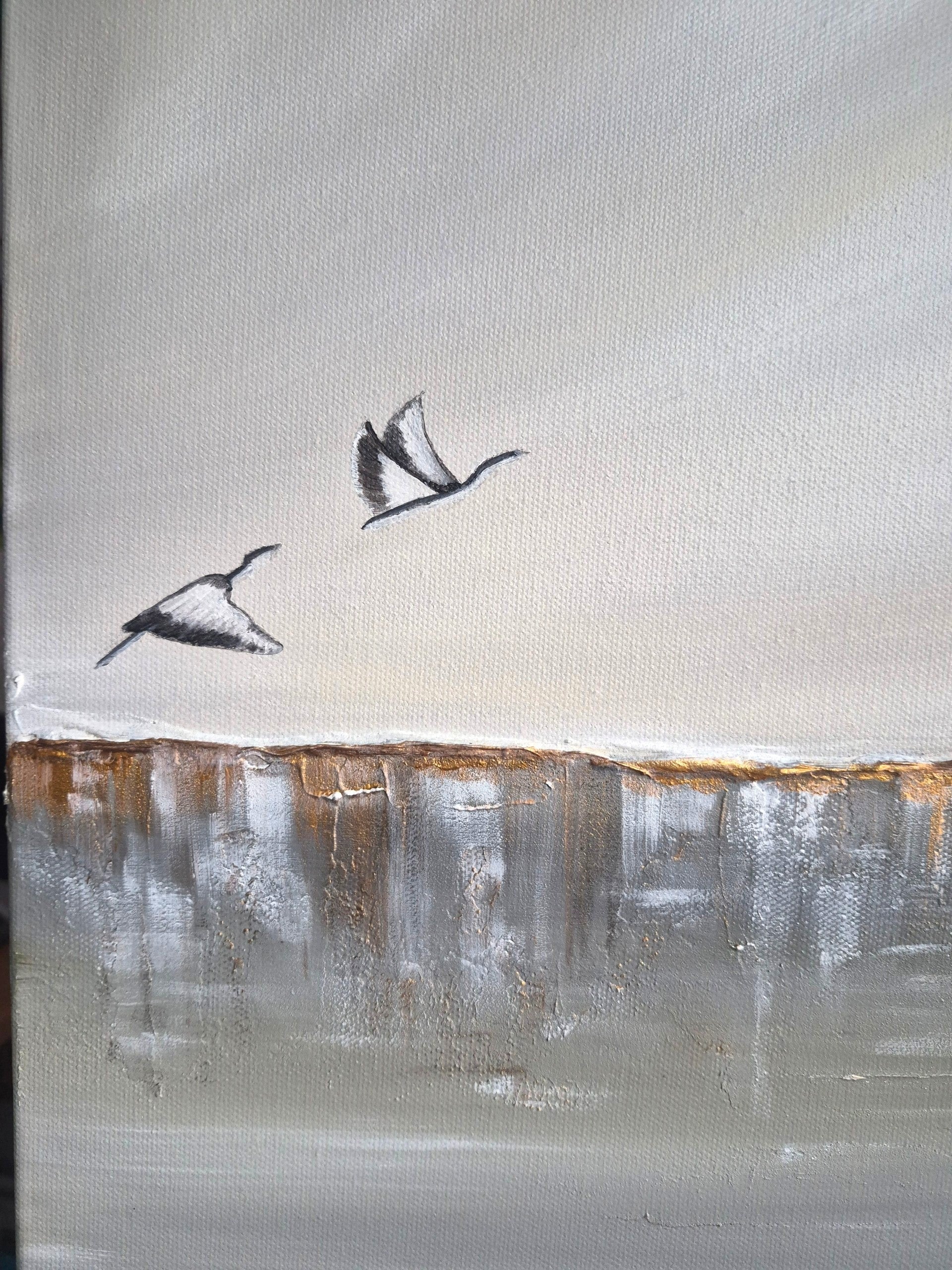 An abstract landscape painting featuring two flying black and white birds against a textured light gray and beige sky, with a horizontal band of brown and gray brushstrokes resembling a shoreline or horizon.